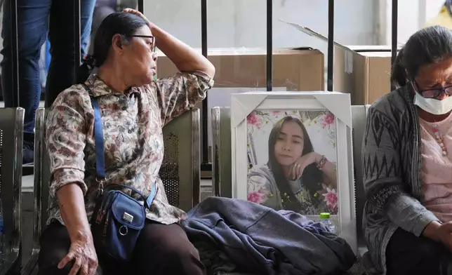 Relatives wait at a hospital to receive bodies of victims, a day after a construction crane fell into a passenger train in Nakhon Ratchasima province, Thailand, Thursday, Jan.15, 2026. (AP Photo/Sakchai Lalit)