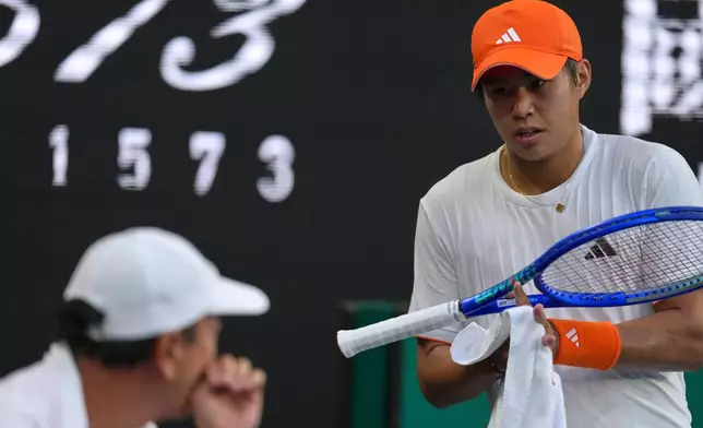 Learner Tien of the U.S. talks to his coach Michael Chang during his fourth round match against Daniil Medvedev of Russia at the Australian Open tennis championship in Melbourne, Australia, Sunday, Jan. 25, 2026. (AP Photo/Asanka Brendon Ratnayake)