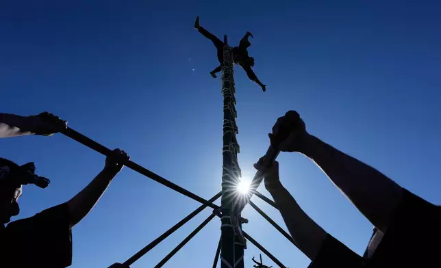 Members of a traditional firefighting preservation group perform ladder stunts during the annual New Year's Fire Brigade Review Tuesday, Jan. 6, 2026, in Tokyo. (AP Photo/Eugene Hoshiko)