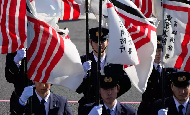 Members of the firefighter hold flags during the annual New Year's Fire Brigade Review Tuesday, Jan. 6, 2026, in Tokyo. (AP Photo/Eugene Hoshiko)