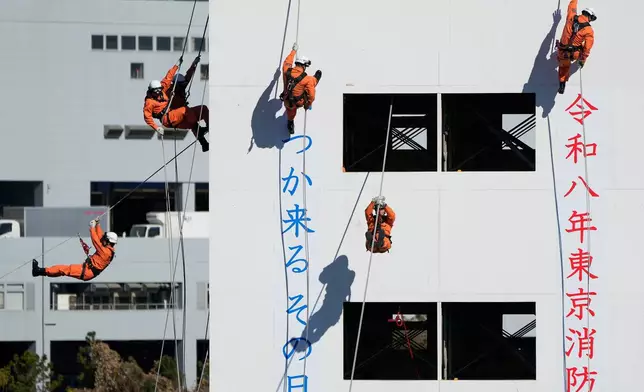 Members of the rescue team perform during the annual New Year's Fire Brigade Review Tuesday, Jan. 6, 2026, in Tokyo. (AP Photo/Eugene Hoshiko)