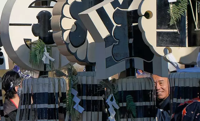 Members of a traditional firefighting preservation group hold a matoi, a traditional flag once used by Edo-period fire brigades during the annual New Year's Fire Brigade Review Tuesday, Jan. 6, 2026, in Tokyo. (AP Photo/Eugene Hoshiko)