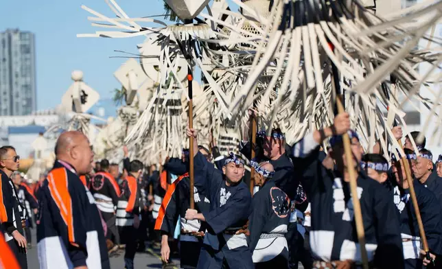 Members of a traditional firefighting preservation group spin a matoi, a traditional flag once used by Edo-period fire brigades during the annual New Year's Fire Brigade Review Tuesday, Jan. 6, 2026, in Tokyo. (AP Photo/Eugene Hoshiko)