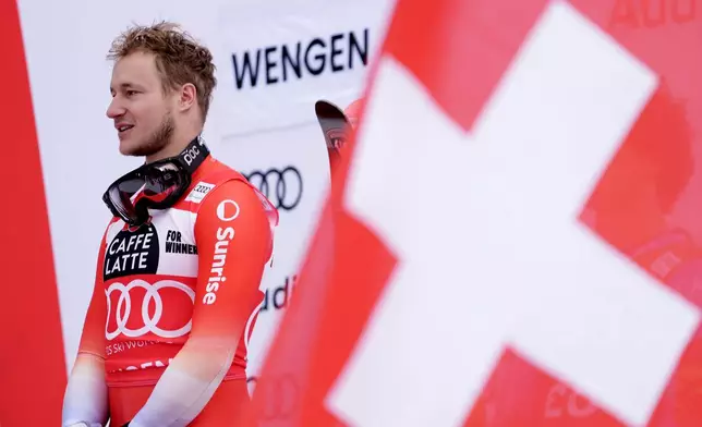 Switzerland's Marco Odermatt listens to the national anthem on the podium after winning an alpine ski, men's World Cup downhill, in Wengen, Switzerland, Saturday, Jan. 17, 2026. (AP Photo/Giovanni Zenoni)