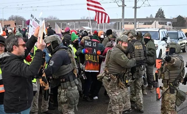 Protesters confront federal agents outside the Bishop Henry Whipple Federal Building, Thursday, Jan. 8, 2026, in Minneapolis, Minn. (AP Photo/Tom Baker)