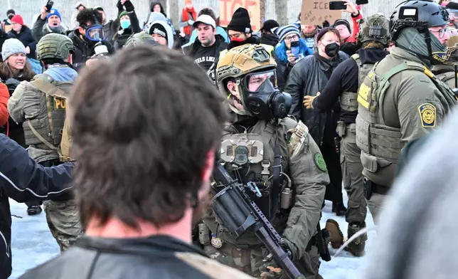 Federal agents confront protesters outside the Bishop Henry Whipple Federal Building, Thursday, Jan. 8, 2026, in Minneapolis, Minn. (AP Photo/Tom Baker)