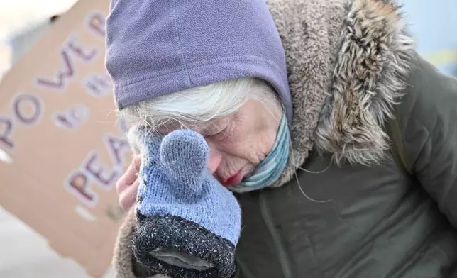 A protester covers their eyes after confronting law enforcement outside the Bishop Henry Whipple Federal Building, Thursday, Jan. 8, 2026, in Minneapolis, Minn. (AP Photo/Tom Baker)