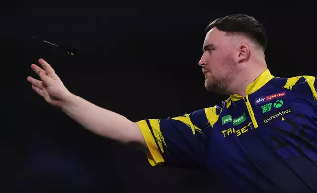 England's Luke Littler throws a dart during the World Darts Championships semifinal match against England's Ryan Searle at Alexandra Palace in London, Friday, Jan. 2, 2026.(AP Photo/Dave Shopland)