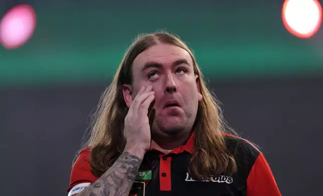 England's Ryan Searle reacts during his semifinal match against England's Luke Littler at the World Darts Championships, at Alexandra Palace in London, Friday, Jan. 2, 2026.(AP Photo/Dave Shopland)