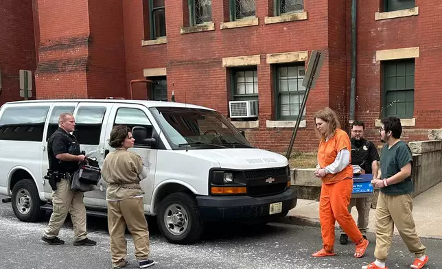 Deputies escort Michelle Zajko, left, Daniel Blank, right, and Jack LaSota, in orange, from the Allegany County Courthouse after a pretrial hearing in Cumberland, Md., on Friday, January 16, 2026. (AP Photo/Mark Scolforo)
