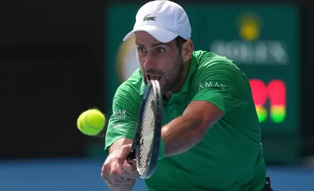 Novak Djokovic of Serbia plays a backhand return to Lorenzo Musetti of Italy during their quarterfinal match at the Australian Open tennis championship in Melbourne, Australia, Wednesday, Jan. 28, 2026. (AP Photo/Dita Alangkara)