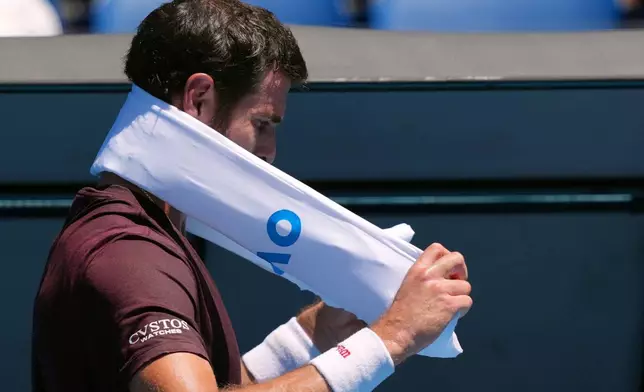 Karen Khachanov of Russia wraps an ice towel around his neck during a break in his third round match against Luciano Darderi of Italy at the Australian Open tennis championship in Melbourne, Australia, Saturday, Jan. 24, 2026. (AP Photo/Dar Yasin)