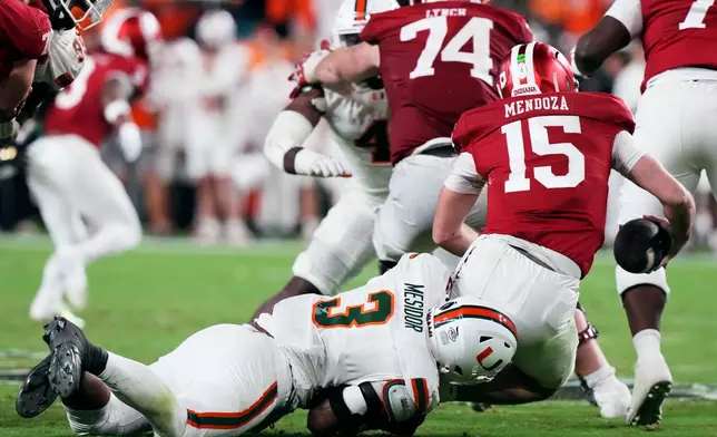 Indiana quarterback Fernando Mendoza is sacked by Miami defensive lineman Akheem Mesidor during the second half of the College Football Playoff national championship game, Monday, Jan. 19, 2026, in Miami Gardens, Fla. (AP Photo/Marta Lavandier)