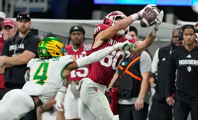Indiana wide receiver Charlie Becker (80) pulls in a pass against Oregon defensive back Brandon Finney (4) during the second half of the Peach Bowl NCAA college football playoff semifinal, Friday, Jan. 9, 2026, in Atlanta. (AP Photo/Brynn Anderson)