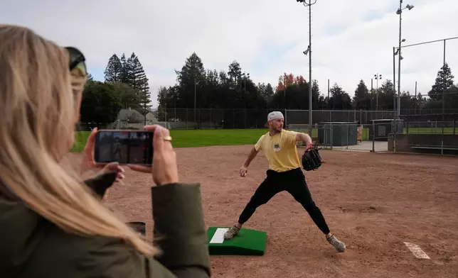 Daulton Jefferies is recorded by his wife Natalie, foreground, as he throws a pitch at Heather Farms Park in Walnut Creek, Calif., Saturday, Dec. 13, 2025. (AP Photo/Godofredo A. Vásquez)
