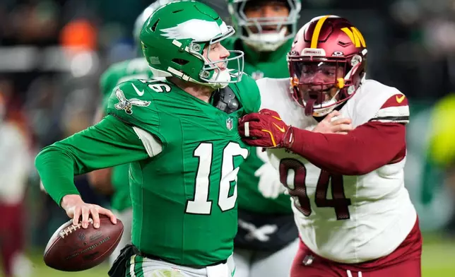 Philadelphia Eagles quarterback Tanner McKee (16) looks to pass while under pressure from Washington Commanders defensive tackle Daron Payne (94) during the second half of an NFL football game Sunday, Jan. 4, 2026, in Philadelphia. (AP Photo/Chris Szagola)