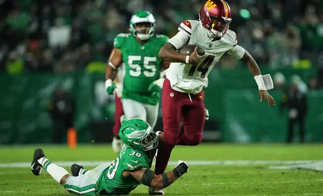 Washington Commanders quarterback Josh Johnson (14) is brought down by Philadelphia Eagles linebacker Jihaad Campbell (30) during the second half of an NFL football game Sunday, Jan. 4, 2026, in Philadelphia. (AP Photo/Matt Rourke)