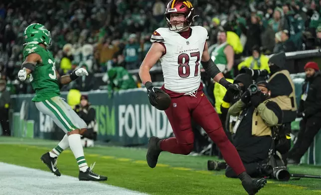 Washington Commanders tight end John Bates (87) scores a touchdown in front of Philadelphia Eagles linebacker Jihaad Campbell (30) during the second half of an NFL football game on Sunday, Jan. 4, 2026, in Philadelphia. (AP Photo/Matt Rourke)