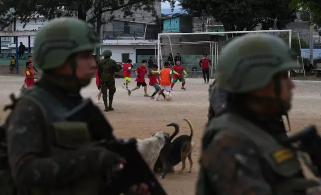 Soldiers receive instructions on a soccer field before patrolling the city during the country's state of emergency, following an escalation of gang-related violence, on the outskirts of Guatemala City, Tuesday, Jan. 20, 2026. (AP Photo/Moises Castillo)