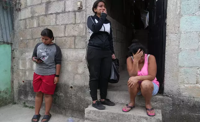 Locals react after finding the body of a neighbor inside their shared house during the country's state of emergency, following an escalation of gang-related violence, on the outskirts of Guatemala City, Tuesday, Jan. 20, 2026. (AP Photo/Moises Castillo)