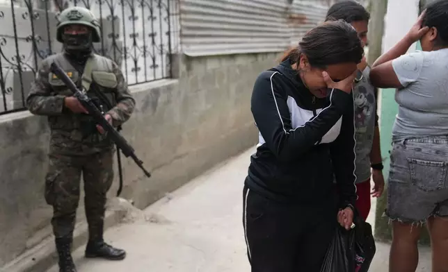 Locals react after finding the body of a neighbor inside their shared house during the country's state of emergency, following an escalation of gang-related violence, on the outskirts of Guatemala City, Tuesday, Jan. 20, 2026. (AP Photo/Moises Castillo)