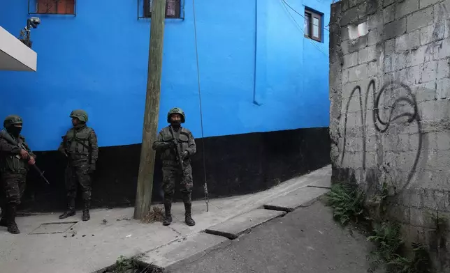 Soldiers patrol an area next to a piece of graffiti referring to the Mara Salvatrucha gang during the country's state of emergency, following an escalation of gang-related violence, on the outskirts of Guatemala City, Tuesday, Jan. 20, 2026. (AP Photo/Moises Castillo)