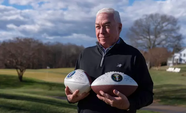Michael Thomas, the former manager of the Courses at Andrews at Joint Base Andrews, stands with footballs autographed by several former presidents, Friday, Dec. 19, 2025, in Lothian, Md. (AP Photo/Mark Schiefelbein)