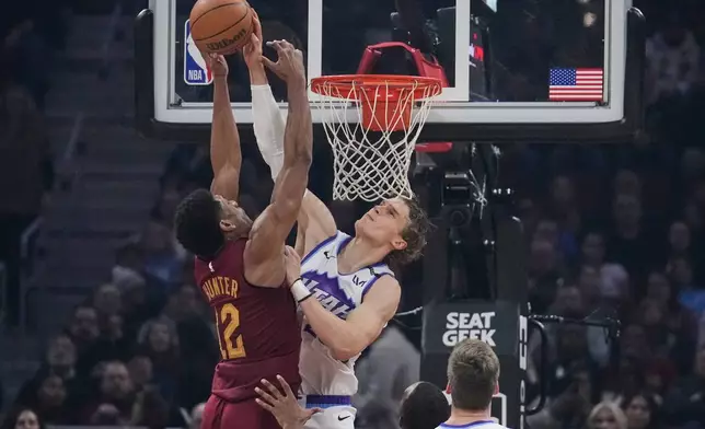 Utah Jazz forward Lauri Markkanen, right, blocks a shot by Cleveland Cavaliers forward De'andre Hunter (12) in the first half of an NBA basketball game in Cleveland, Monday, Jan. 12, 2026. (AP Photo/Sue Ogrocki)