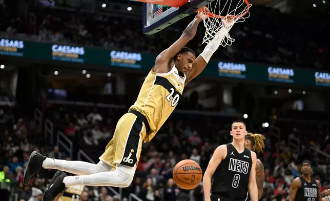 Washington Wizards center Alex Sarr (20) dunks against Brooklyn Nets guard Egor Demin (8) during the first half of an NBA basketball game, Friday, Jan. 2, 2026, in Washington. (AP Photo/John McDonnell)