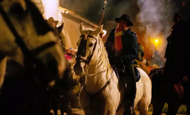 Riders on their horses wait to jump over the bonfires as part of a ritual in honor of Saint Anthony the Abbot, the patron saint of domestic animals, in San Bartolome de Pinares, Spain, Friday, Jan. 16, 2026. (AP Photo/Manu Fernandez)