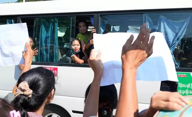 Released prisoners, in a bus, are welcomed by family members and colleagues after they left Insein Prison Sunday, Jan. 4, 2026, in Yangon, Myanmar. (AP Photo/Thein Zaw)