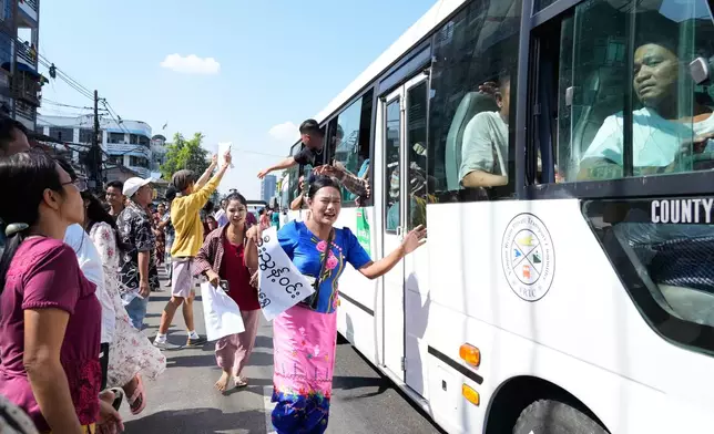 Released prisoners, in a bus, are welcomed by family members and colleagues after they left Insein Prison Sunday, Jan. 4, 2026, in Yangon, Myanmar. (AP Photo/Thein Zaw)