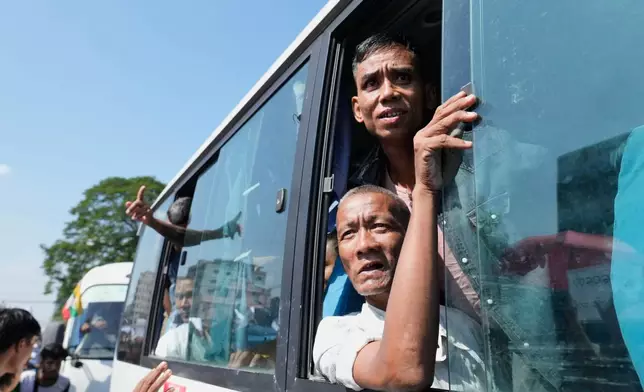 Released prisoners, in a bus, are welcomed by family members and colleagues after they left Insein Prison Sunday, Jan. 4, 2026, in Yangon, Myanmar. (AP Photo/Thein Zaw)