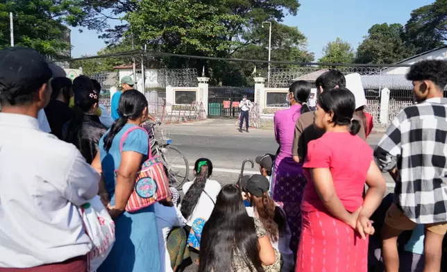 Family members and colleagues wait to welcome the released prisoners from Insein Prison Sunday, Jan. 4, 2026, in Yangon, Myanmar. (AP Photo/Thein Zaw)