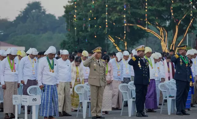 Myanmar's government officials salute at their national flag during a ceremony marking the 78th anniversary of its Independence Day in Naypyitaw, Myanmar, Sunday, Jan. 4, 2026. (AP Photo/Aung Shine Oo)