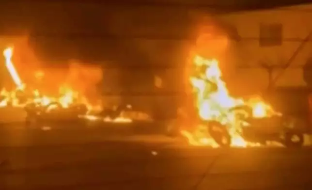 This frame grab from a video released by Iran state TV shows vehicles burning amid night of mass protests in Tehran, Iran, Thursday, Jan. 8, 2026. (Iran state TV via AP)