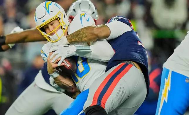 Los Angeles Chargers quarterback Justin Herbert (10) is sacked by New England Patriots linebacker Anfernee Jennings (33) in the second half of an NFL wild-card playoff football game in Foxborough, Mass., Sunday, Jan. 11, 2026. (AP Photo/Robert F. Bukaty)