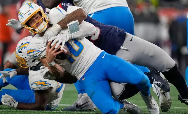 Los Angeles Chargers quarterback Justin Herbert (10) is sacked by New England Patriots linebacker Anfernee Jennings, rear, in the second half of an NFL wild-card playoff football game in Foxborough, Mass., Sunday, Jan. 11, 2026. (AP Photo/Charles Krupa)