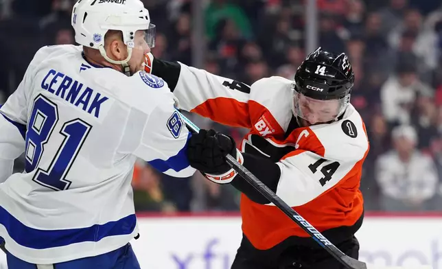 Philadelphia Flyers' Sean Couturier (14) checks Tampa Bay Lightning's Erik Cernak (81) during the second period of an NHL hockey game, Saturday, Jan. 10, 2026, in Philadelphia. (AP Photo/Derik Hamilton)