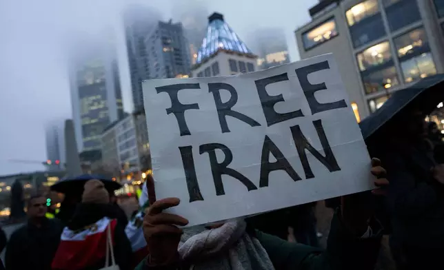 People attend a rally in Frankfurt, Germany, Monday, Jan. 12, 2026. (Boris Roessler/dpa via AP)