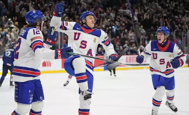 United States forward Ryker Lee, center, celebrates after scoring a goal during the third period of an IIHF World Junior Hockey Championship quarterfinals game against Finland, Friday, Jan. 2, 2026, in St. Paul, Minn. (AP Photo/Abbie Parr)