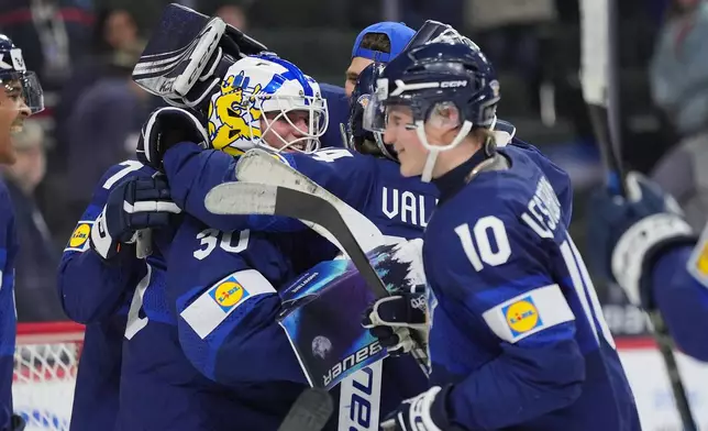 Finland goalie Petteri Rimpinen (30), left, celebrates with teammates after an overtime win against the United States of an IIHF World Junior Hockey Championship quarterfinals game, Friday, Jan. 2, 2026, in St. Paul, Minn. (AP Photo/Abbie Parr)