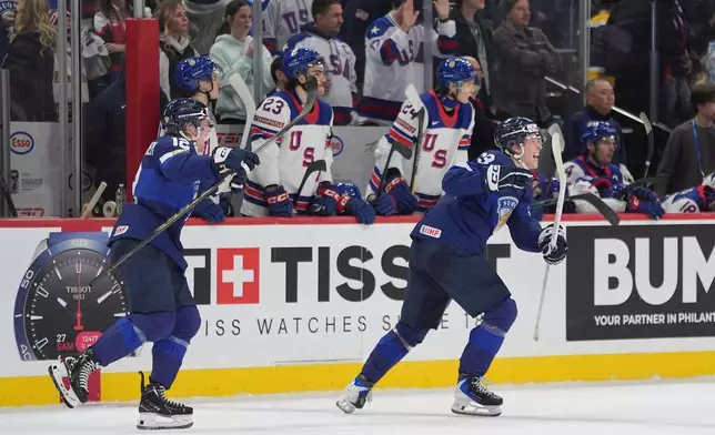 Finland forwards Joona Saarelainen (12), left, and forward Leo Tuuva (23) celebrate after the overtime win against the United States of an IIHF World Junior Hockey Championship quarterfinals game, Friday, Jan. 2, 2026, in St. Paul, Minn. (AP Photo/Abbie Parr)