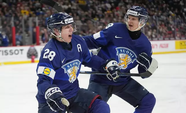 Finland forward Heikki Ruohonen (28) celebrates with defenseman Veeti Vaisanen (13) after scoring a goal during the second period of an IIHF World Junior Hockey Championship quarterfinals game against the United States, Friday, Jan. 2, 2026, in St. Paul, Minn. (AP Photo/Abbie Parr)
