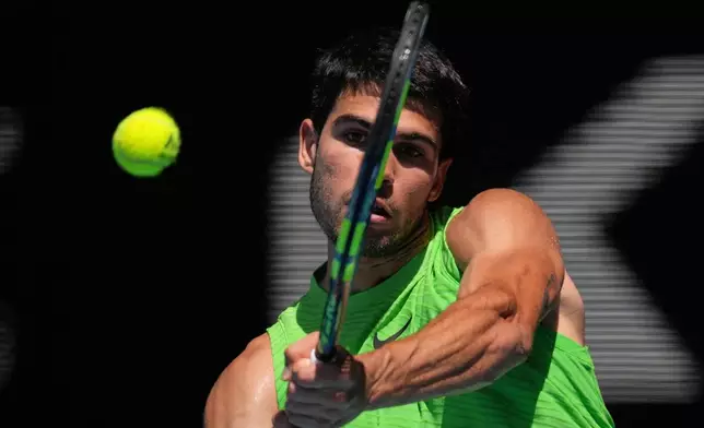 Carlos Alcaraz of Spain plays a backhand return to Tommy Paul of the U.S. during their fourth round match at the Australian Open tennis championship in Melbourne, Australia, Sunday, Jan. 25, 2026. (AP Photo/Dita Alangkara)