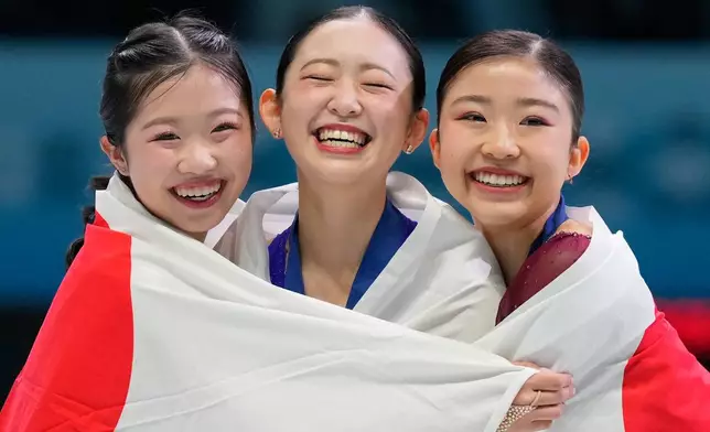 From left silver medalist Ami Nakai of Japan, gold medalist Yuna Aoki of Japan and bronze medalist Mone Chiba of Japan celebrate with Japan national flags after the Women Free Skating of the ISU Four Continents Figure Skating Championships in Beijing, China, Friday, Jan. 23, 2026. (AP Photo/Vincent Thian)