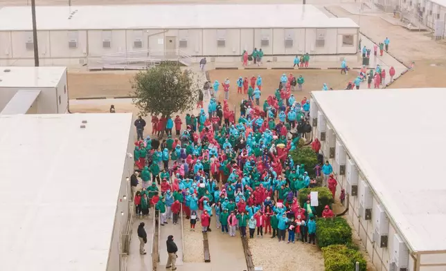Detainees held at the South Texas Family Residential Center wave signs during a demonstration in Dilley, Texas, Saturday, Jan. 24, 2026. (AP Photo/Brenda Bazán)