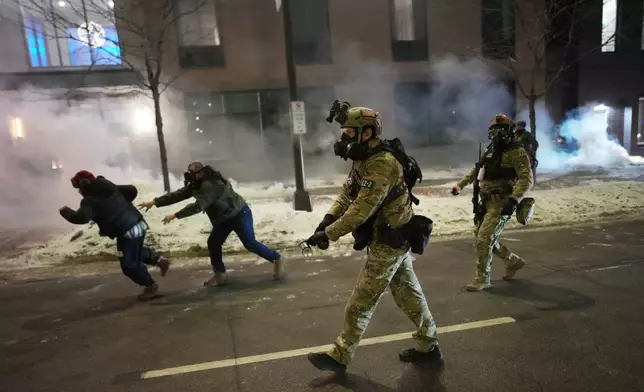 Federal agents try to clear demonstrators near a hotel, using tear gas during a noise demonstration protest in response to federal immigration enforcement operations in the city Sunday, Jan. 25, 2026, in Minneapolis. (AP Photo/Adam Gray)