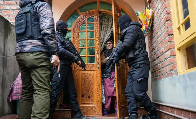 Jammu and Kashmir Special Operation Group (SOG) personnel question local residents during a house-to-house search operation as part of heightened security measures ahead of India's Republic Day in Srinagar, Indian controlled Kashmir, Sunday, Jan. 25, 2026. (AP Photo/Mukhtar Khan)