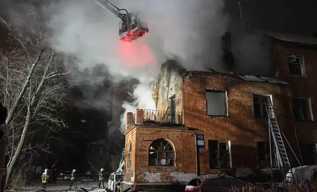 Rescue workers put out a fire at a residential building damaged by a Russian strike in Kyiv, Ukraine, Friday, Jan. 9, 2026. (AP Photo/Efrem Lukatsky)